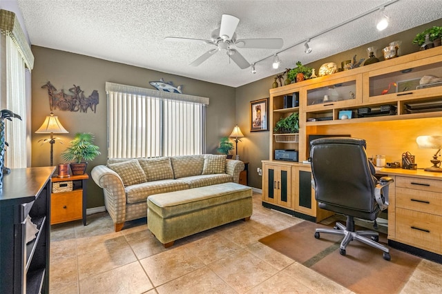 home office featuring ceiling fan, light tile patterned flooring, and a textured ceiling