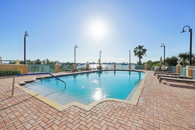 community pool with fence and a patio area