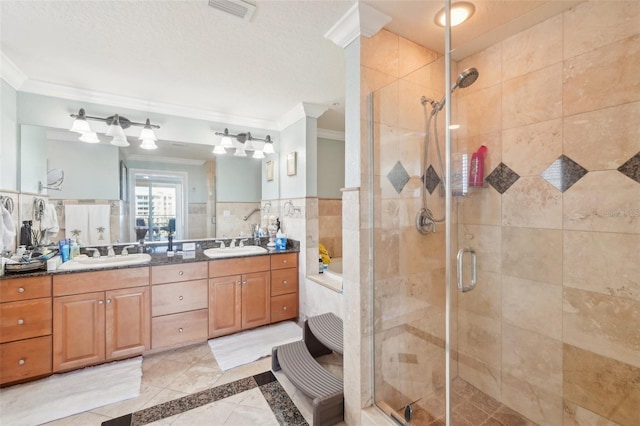 bathroom featuring a sink, visible vents, a stall shower, and ornamental molding