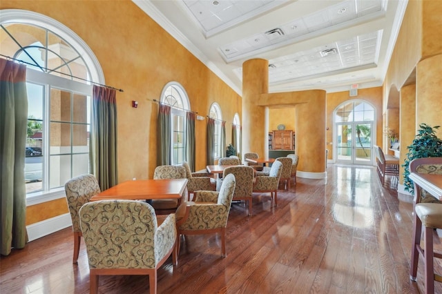 dining space with baseboards, crown molding, and hardwood / wood-style flooring