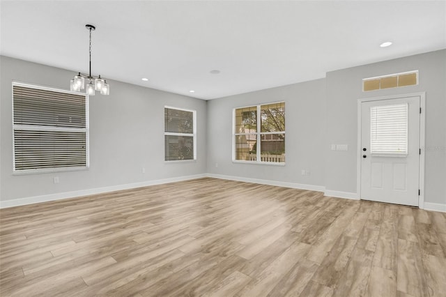 unfurnished living room featuring light wood-type flooring, visible vents, baseboards, and recessed lighting