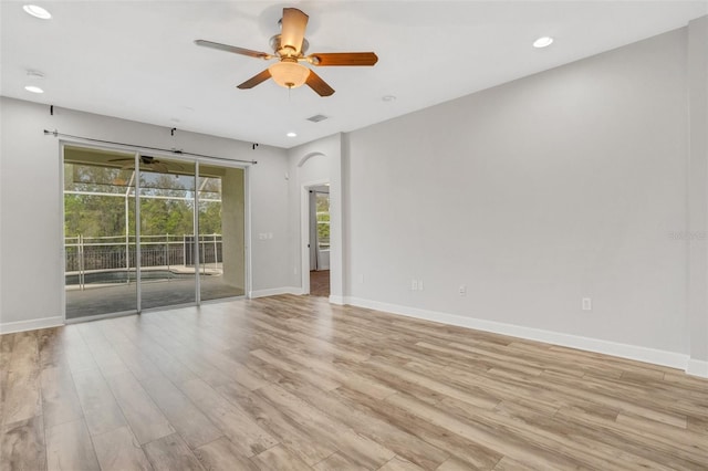 unfurnished room with plenty of natural light, baseboards, light wood-style floors, and ceiling fan