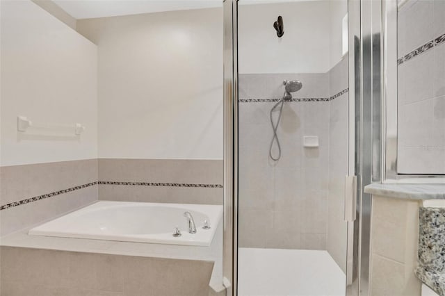 bathroom featuring a bath and a stall shower