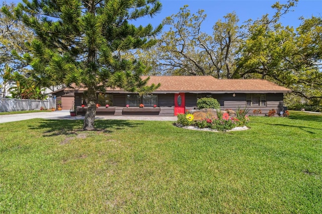 ranch-style home with a front lawn, concrete driveway, and fence