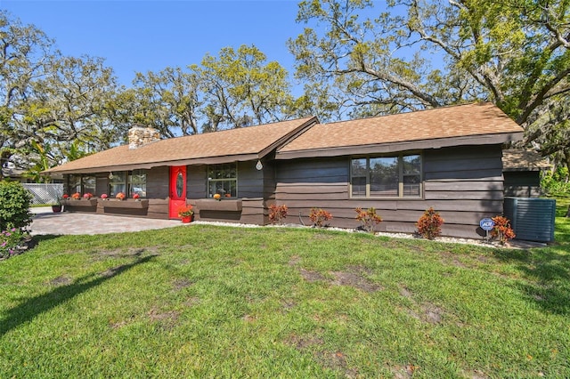 view of front of property with fence, a front yard, an outdoor hangout area, a chimney, and a patio