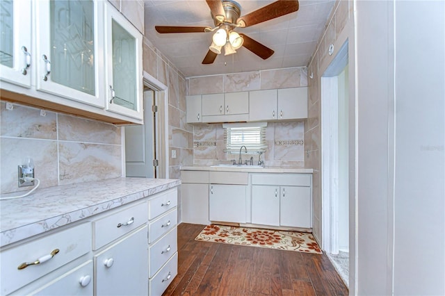 kitchen with a ceiling fan, dark wood finished floors, a sink, light countertops, and white cabinetry