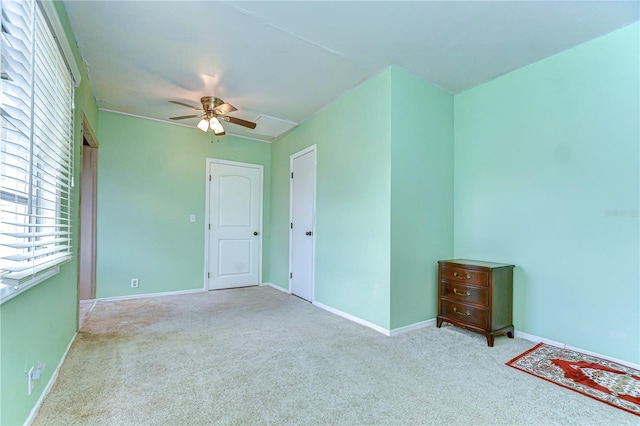 unfurnished room with carpet flooring, baseboards, and a ceiling fan