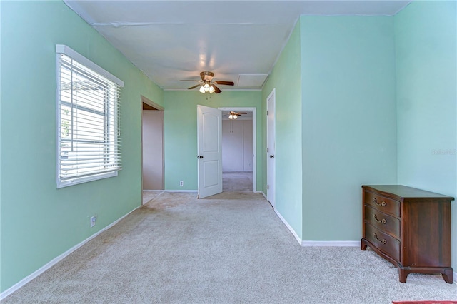 unfurnished bedroom with light colored carpet, baseboards, and ceiling fan