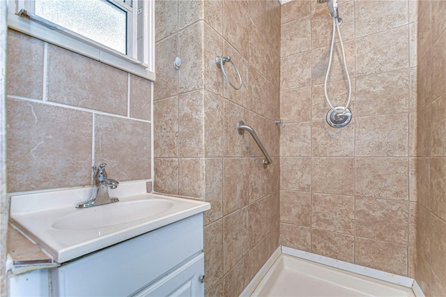 full bathroom with vanity and a tile shower