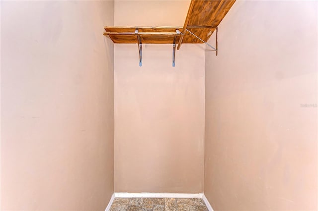 spacious closet with stone finish floor