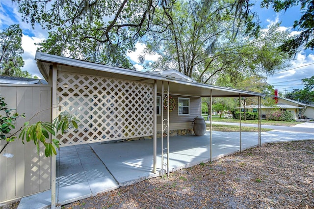 view of patio / terrace with a carport and fence