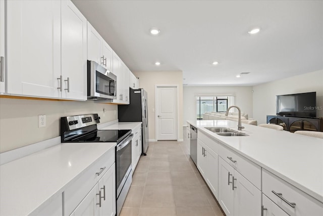 kitchen with white cabinetry, light countertops, appliances with stainless steel finishes, and a sink