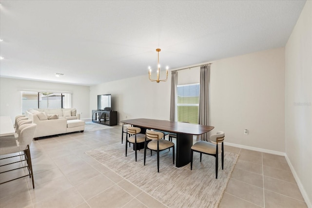 dining space featuring light tile patterned floors, baseboards, and an inviting chandelier