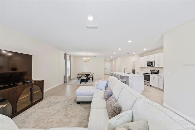 living area featuring visible vents, baseboards, a chandelier, light tile patterned floors, and recessed lighting