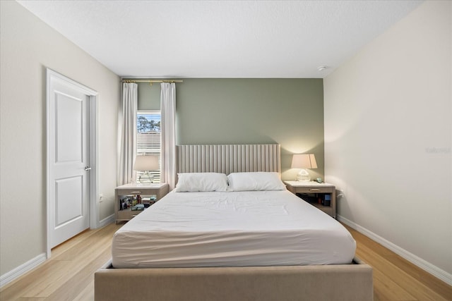 bedroom with baseboards and light wood-style floors