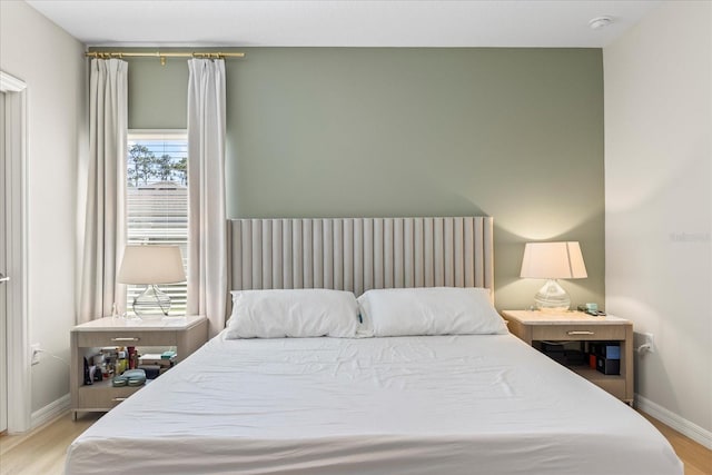 bedroom featuring baseboards and wood finished floors