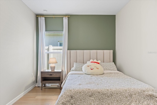 bedroom featuring wood finished floors and baseboards