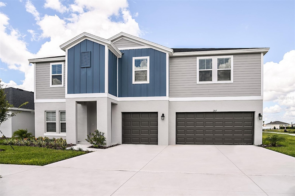 view of front of house featuring a garage, board and batten siding, concrete driveway, and stucco siding