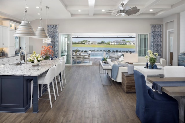 dining space with ceiling fan, beam ceiling, coffered ceiling, and dark wood-style floors