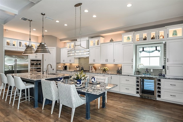 kitchen featuring a sink, wine cooler, dark wood-style flooring, and white cabinetry