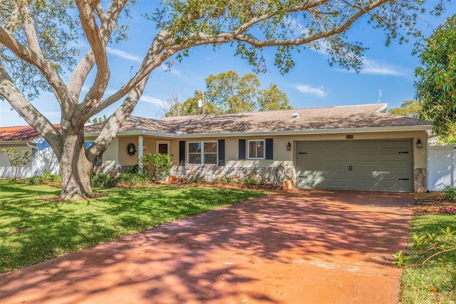 ranch-style home featuring stucco siding, a front yard, a garage, and driveway