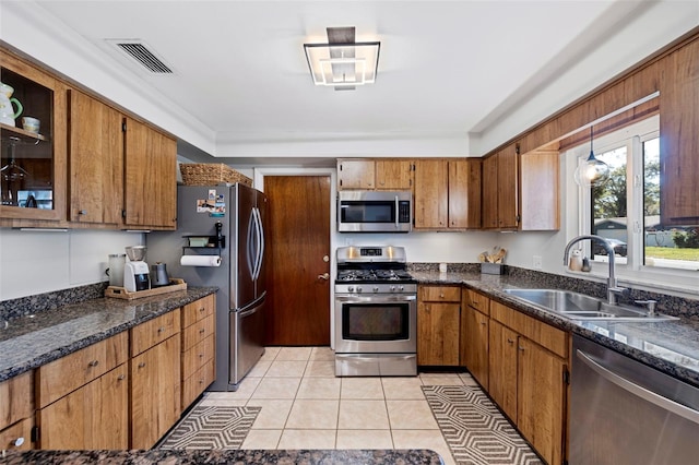 kitchen featuring visible vents, brown cabinets, a sink, stainless steel appliances, and light tile patterned floors