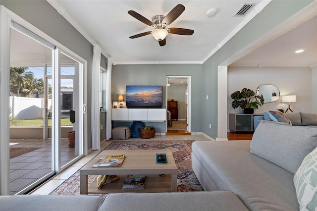 living area featuring visible vents, ornamental molding, a ceiling fan, and tile patterned flooring