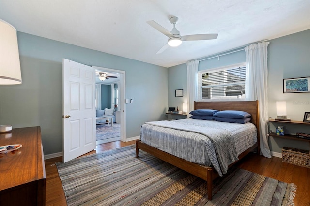 bedroom featuring ceiling fan, baseboards, and wood finished floors