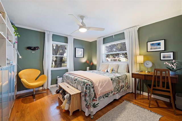 bedroom featuring multiple windows, wood finished floors, and baseboards