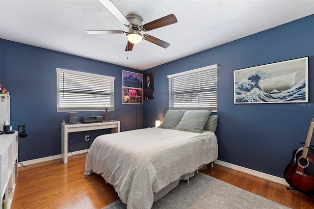 bedroom featuring a ceiling fan, wood finished floors, and baseboards