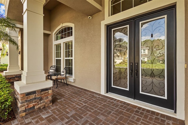 doorway to property featuring french doors and stucco siding