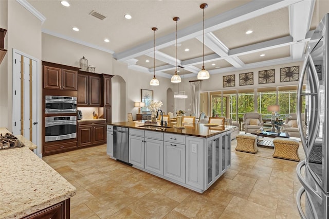 kitchen featuring visible vents, arched walkways, coffered ceiling, stainless steel appliances, and a sink