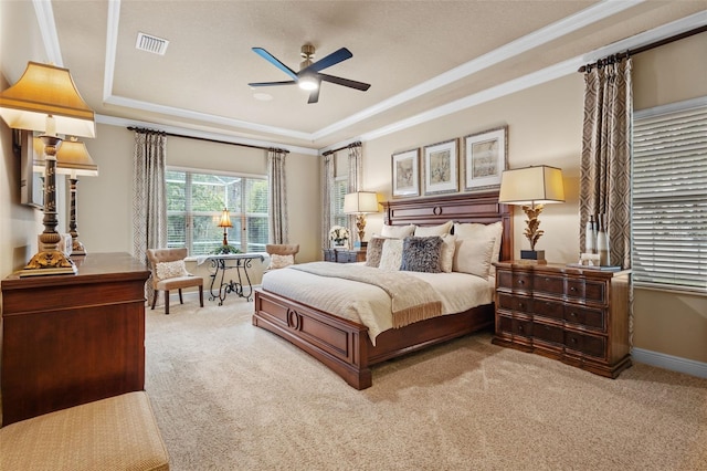 bedroom with visible vents, crown molding, a tray ceiling, and carpet floors