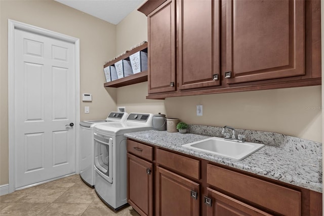 clothes washing area featuring a sink, cabinet space, independent washer and dryer, and light tile patterned floors