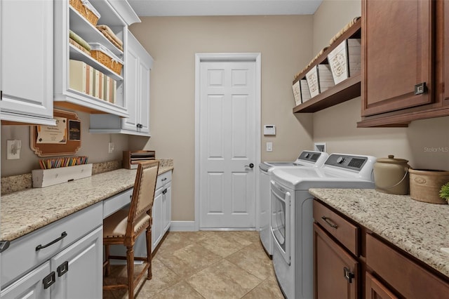 clothes washing area featuring cabinet space, light tile patterned floors, washer and dryer, and baseboards