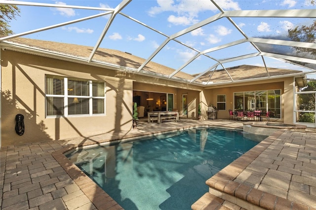 view of pool with a pool with connected hot tub, a lanai, and a patio area