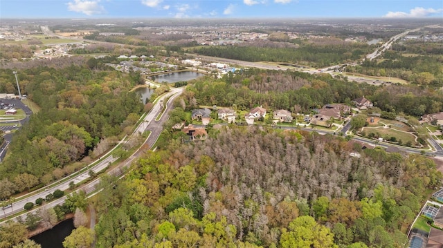 birds eye view of property featuring a forest view and a water view