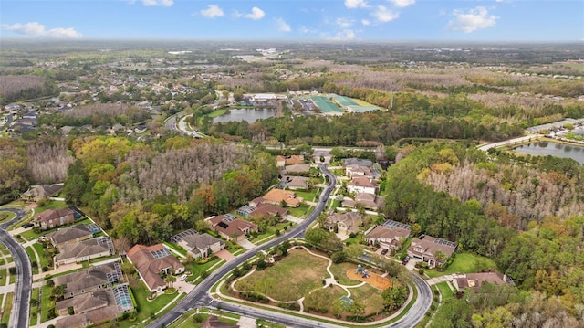 drone / aerial view featuring a forest view, a residential view, and a water view