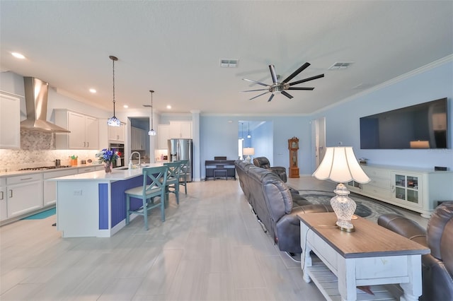 living room with visible vents, a ceiling fan, and crown molding