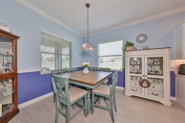 dining area featuring wainscoting, crown molding, and baseboards