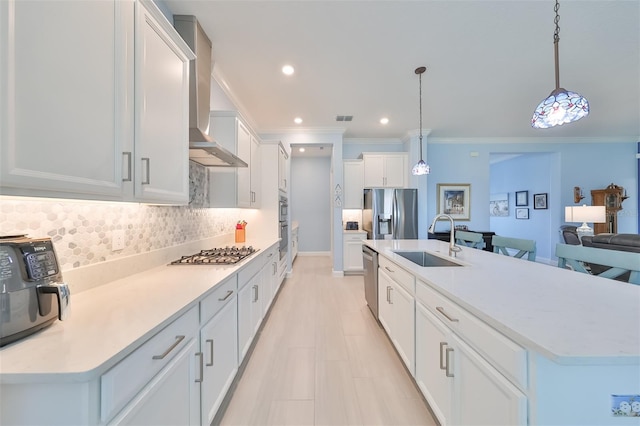 kitchen with tasteful backsplash, visible vents, stainless steel appliances, wall chimney exhaust hood, and a sink