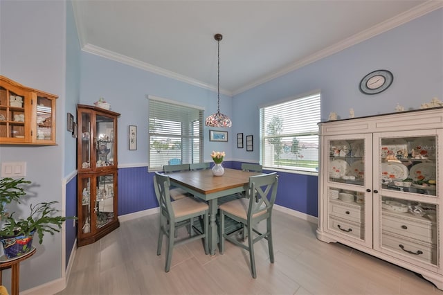 dining space featuring crown molding and a wainscoted wall