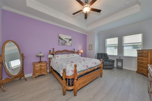 bedroom with a raised ceiling, light wood-style floors, and ornamental molding