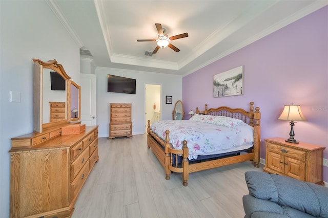 bedroom featuring a ceiling fan, visible vents, light wood finished floors, crown molding, and a raised ceiling