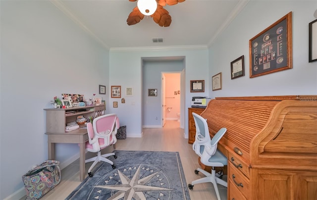 office featuring wood finished floors, baseboards, a ceiling fan, visible vents, and ornamental molding