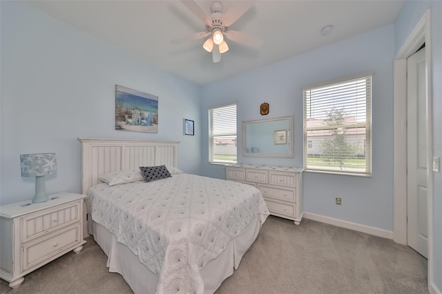 bedroom featuring baseboards, light carpet, and a ceiling fan