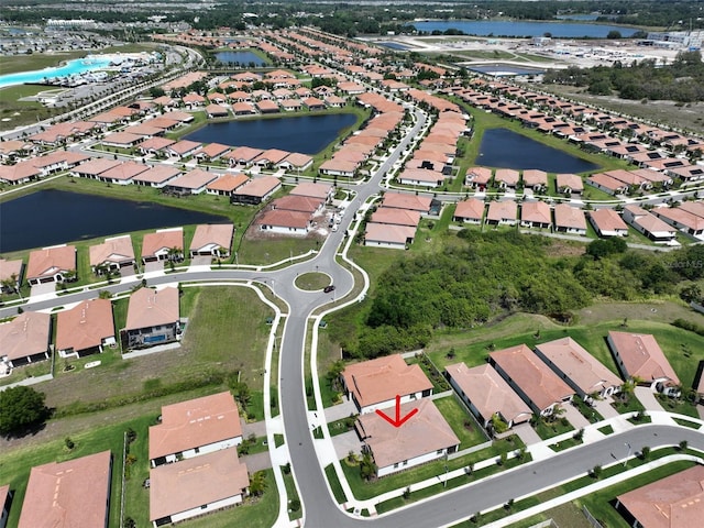 drone / aerial view featuring a residential view and a water view