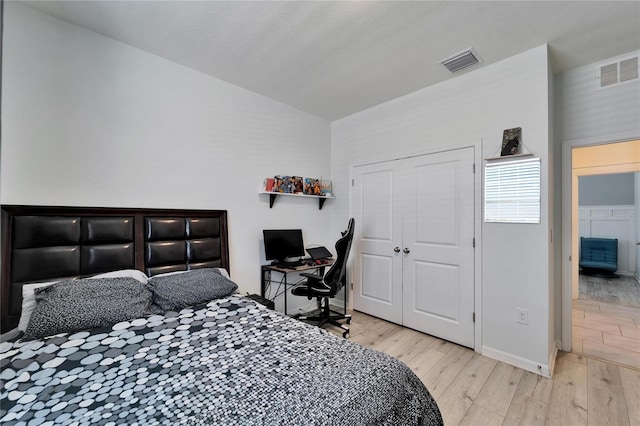 bedroom with baseboards, hardwood / wood-style flooring, lofted ceiling, and visible vents