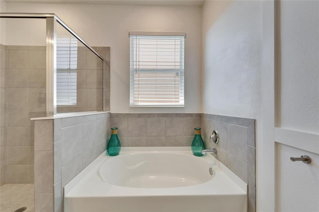 bathroom with a stall shower and a bath