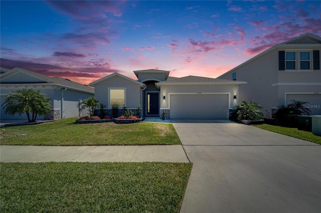 view of front of house with stone siding, concrete driveway, stucco siding, a front lawn, and a garage